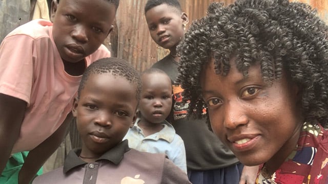Agnes smiling with the kids in Kampala