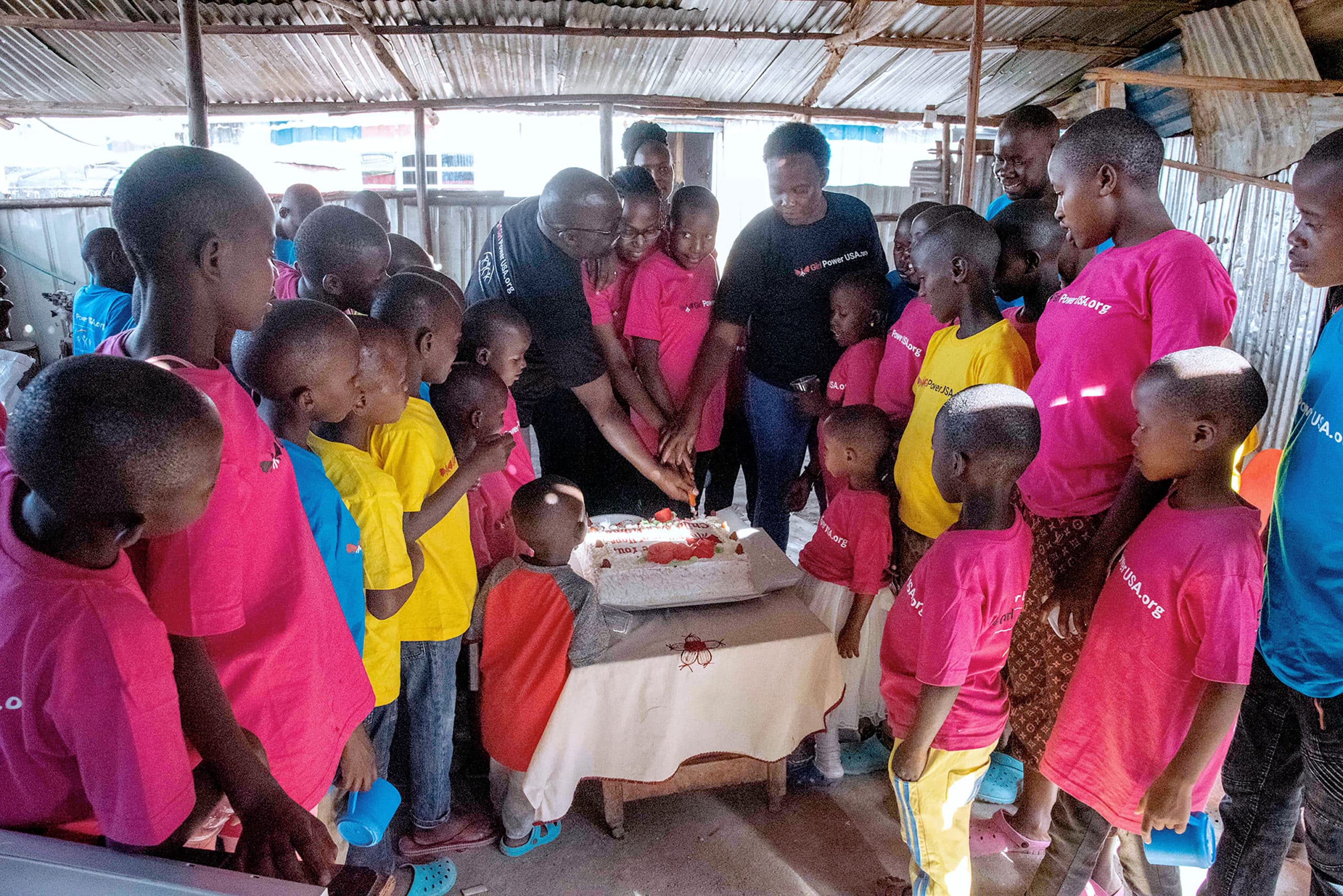 The founders of Pillars of Hope are slicing cake to share with the children. - Solutions to hunger in Africa 