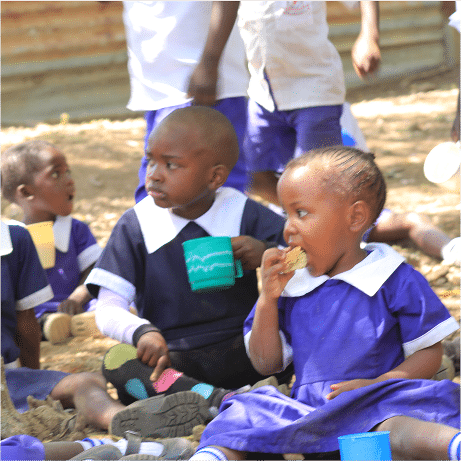 CYAN program’s children eating breakfast on the ground - Supporting Food Security in Africa