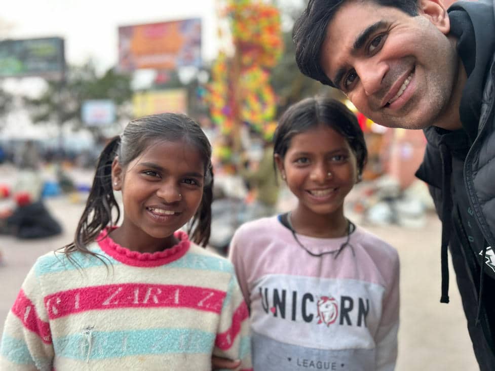 Sameer Somal taking a selfie with two young girls in a local park.